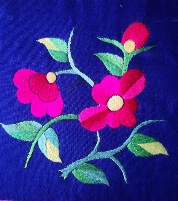Magenta embroidered flowers with pale centres and green stems on deep blue fabric