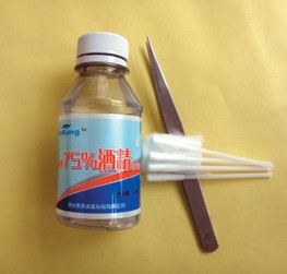 A small bottle, tweezers, and cotton swabs shown as materials for localized grease removal