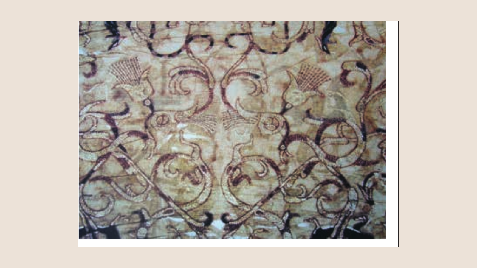 Detail of a Warring States embroidery fragment with linked lines forming intertwined dragons, phoenixes, and a tiger