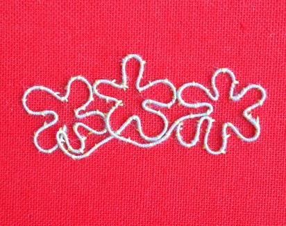 A completed white twining-thread floral outline couched on red cloth