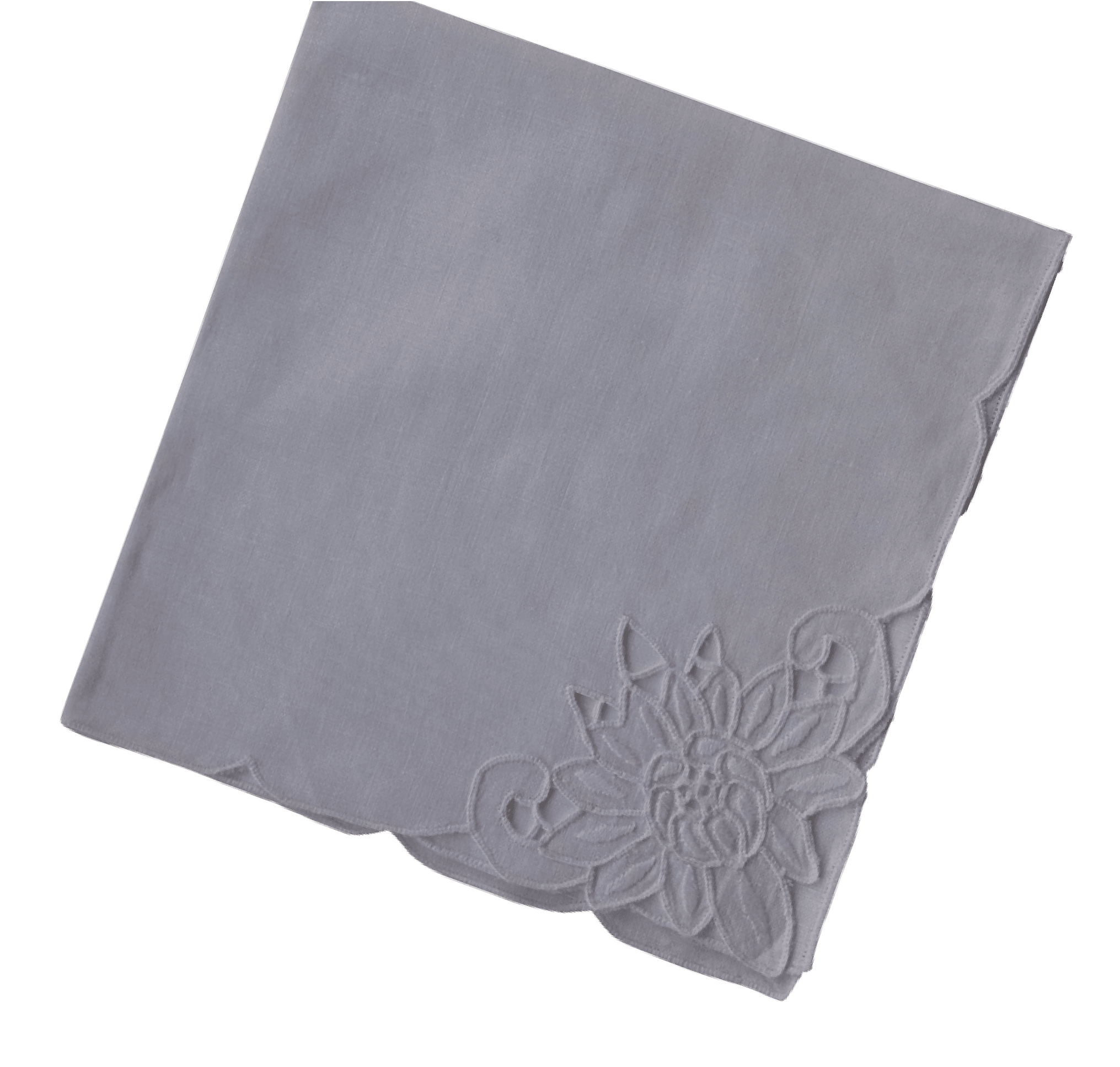 White napkin with a chrysanthemum and curling cutwork forms at one corner, beside a broad area of plain cloth.