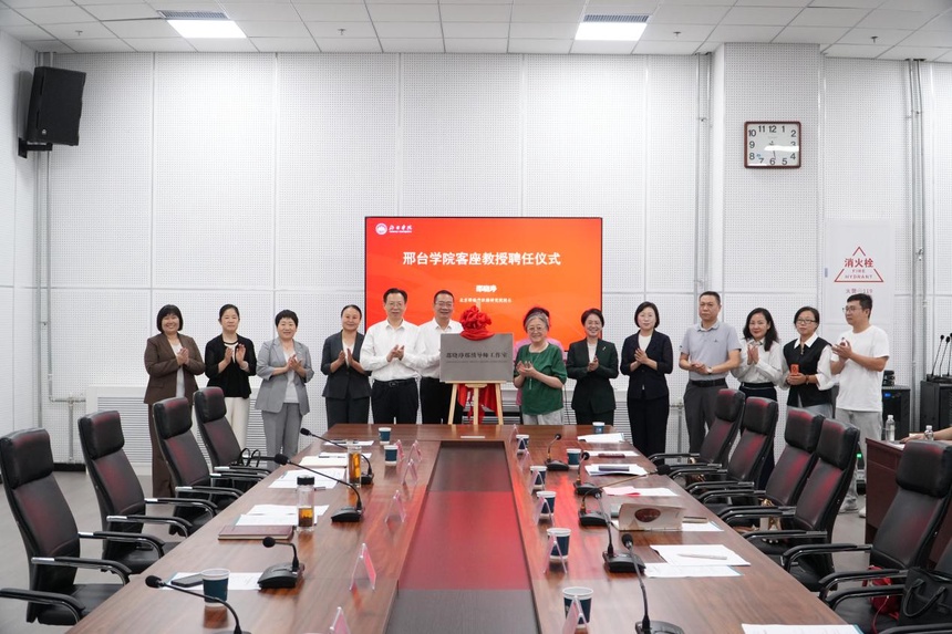 Participants gathered around the mentor studio plaque at Xingtai University.